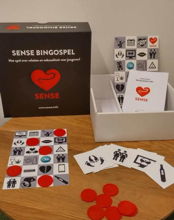 Het Sense Bingospel op een tafel met een handleiding, bingokaarten, afbeeldingen en fiches.