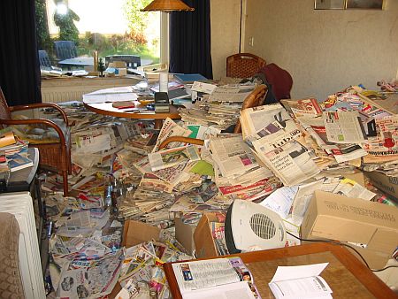 huiskamer vol rotzooi en oude kranten, een dikke laag over de gehele vloer